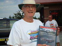 Pete olsen smiles with his Outstanding Cruiser plaque